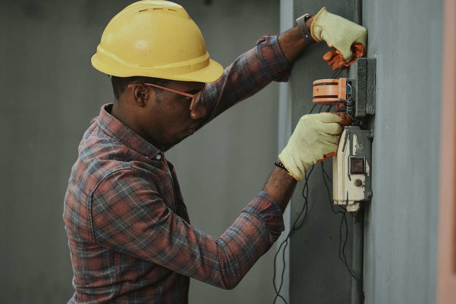 Photo by Emmanuel Ikwuegbu man in brown and white plaid dress shirt and yellow hard hat holding black and orange